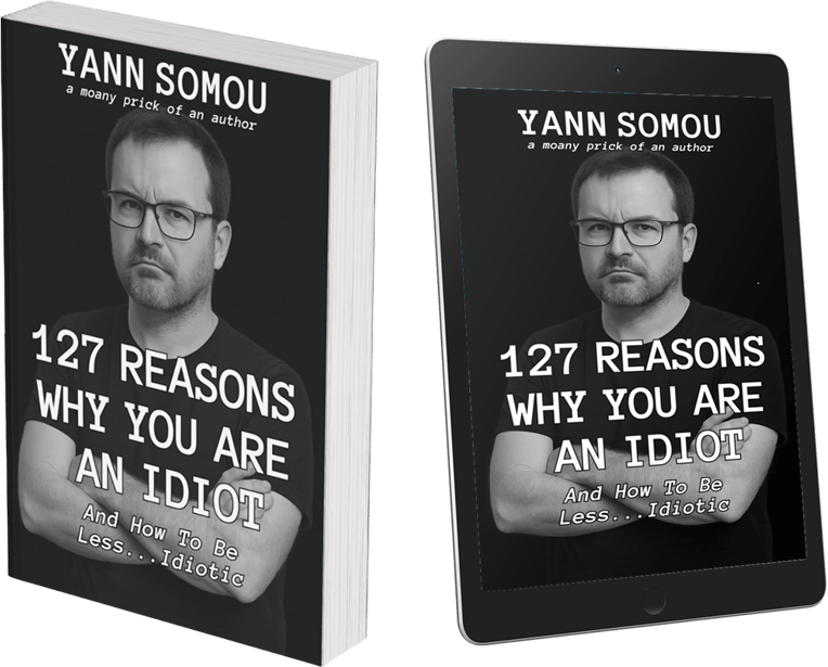 3D image of the book 127 Reasons Why You Are An Idiot by Yann Somou, shown as both a physical paperback and a digital tablet version. The cover features a black-and-white photo of the author with arms crossed, looking unimpressed. Subtitle reads: 'And How To Be Less... Idiotic.'